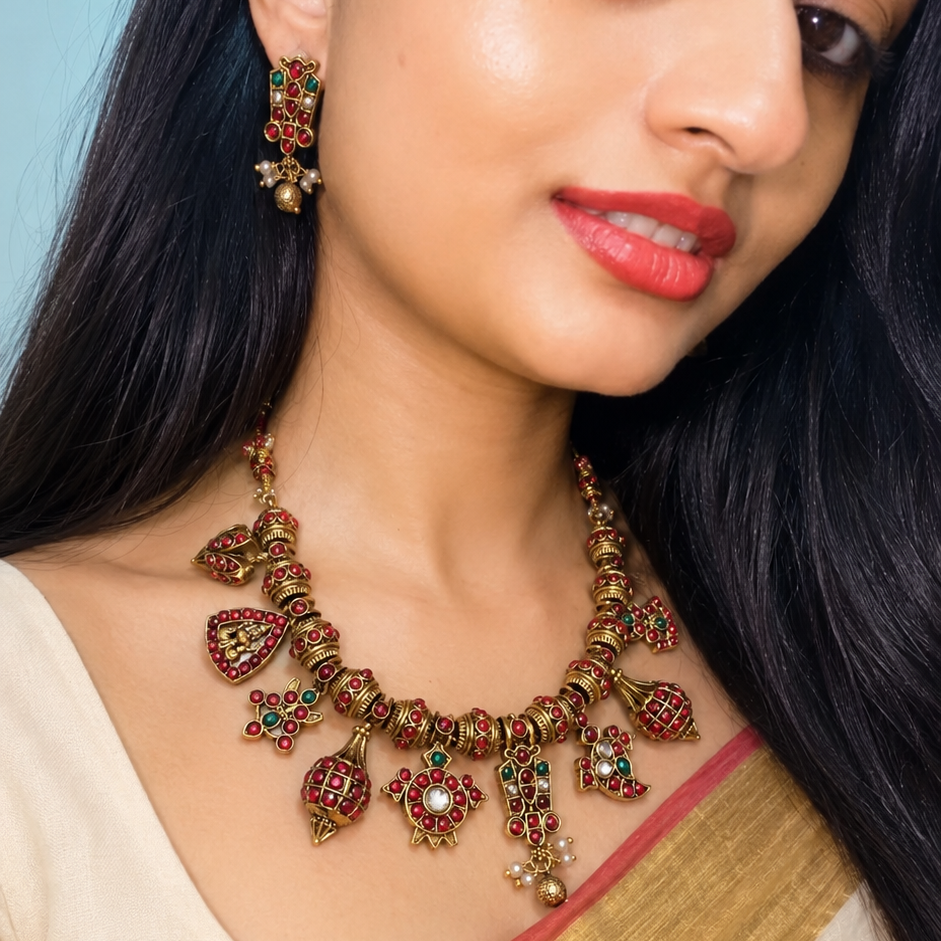 Woman wearing a traditional necklace and earrings with a plain background